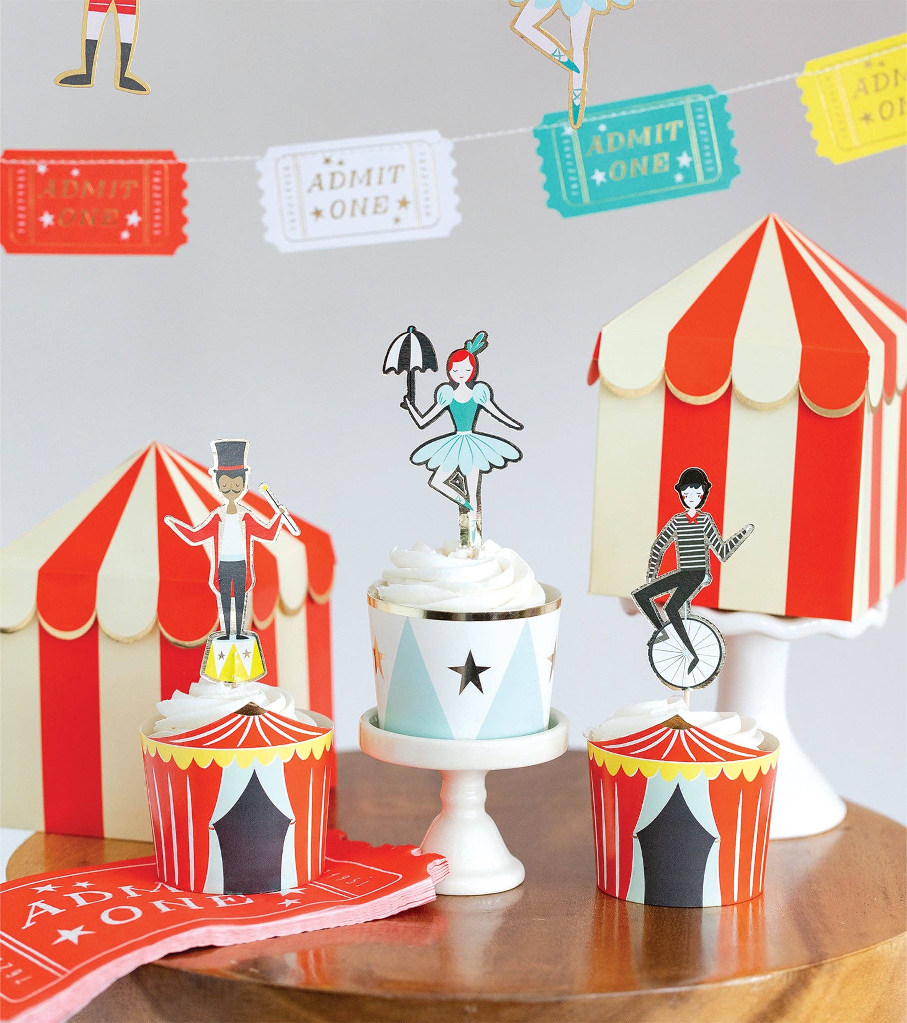 Close-up of carnival cupcake toppers including ballerina, ringmaster, and unicyclist for Toronto parties.