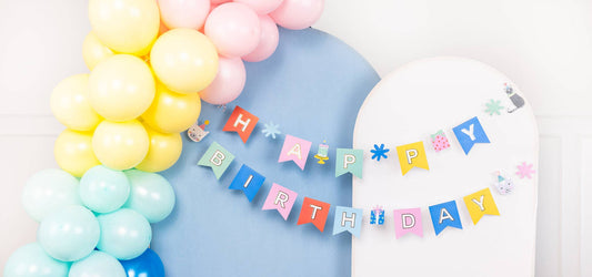 close up of a cat themed happy birthday banner and matching balloon garland