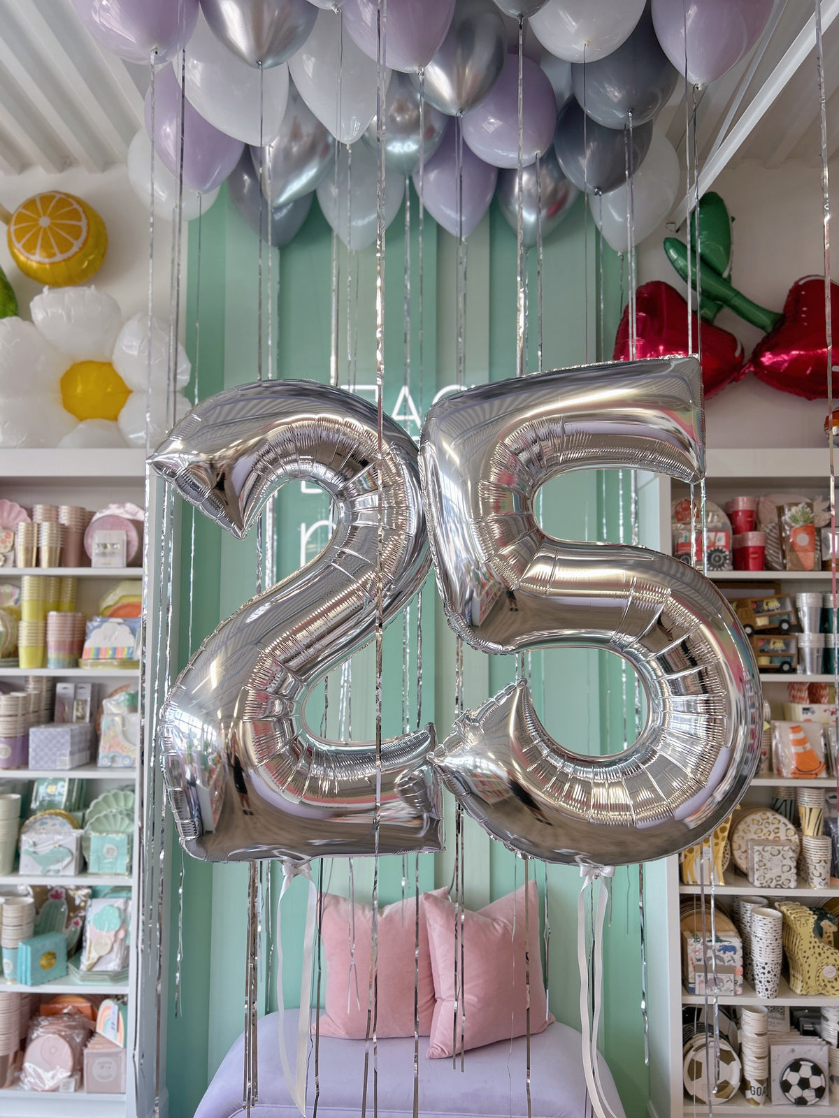 Silver 25 foil number balloons beneath lavender, white and silver helium ceiling balloons with hanging ribbons in Toronto.