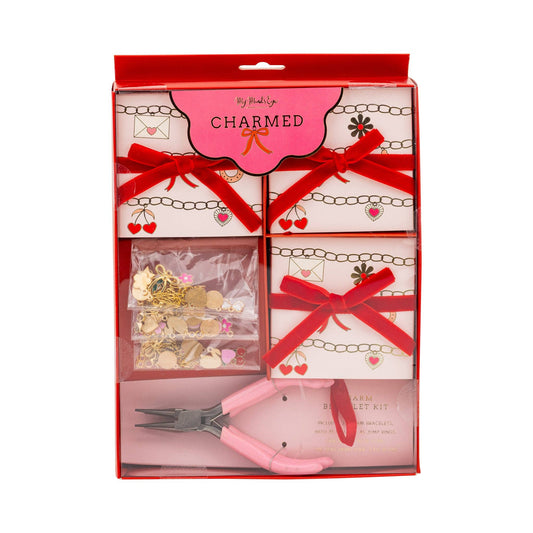 Charm bracelet kit shown in original packaging with bow-wrapped boxes and jewelry pieces