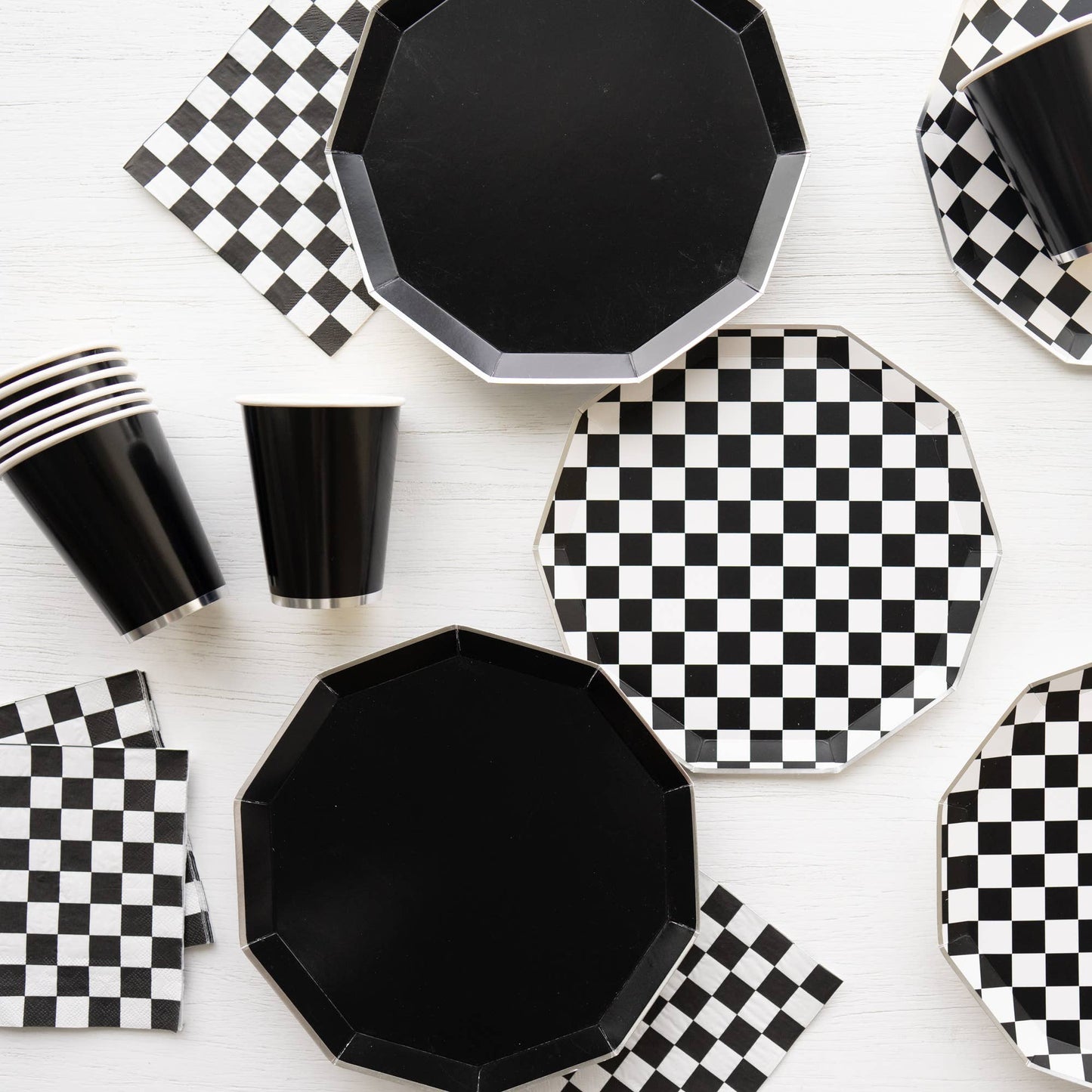 Modern black and white checkerboard party table with plates, cups and napkins, available at our Toronto party shop