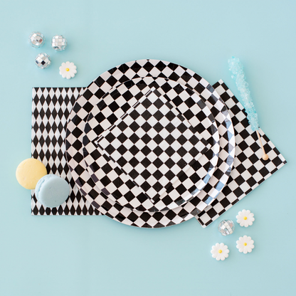 Black checkerboard party plates and napkins styled with pastel macarons and disco details, part of a modern tableware collection shipping across Canada.