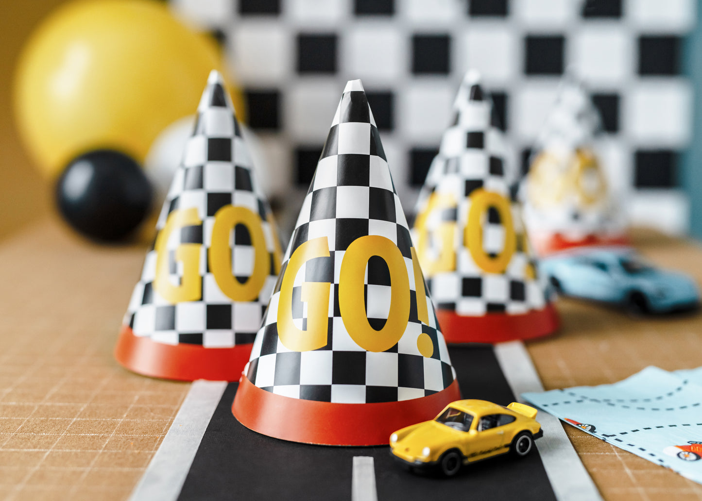 Race car party hats styled with toy cars and décor, sold in Toronto at Confetti My Party. Ships across Canada.