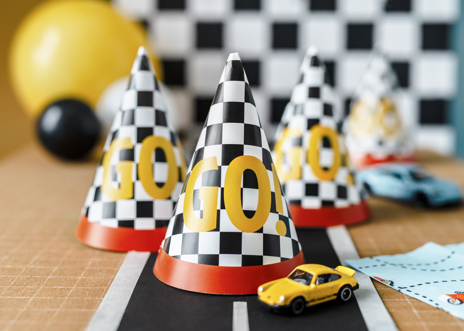 Race car party hats styled with toy cars and décor, sold in Toronto at Confetti My Party. Ships across Canada.