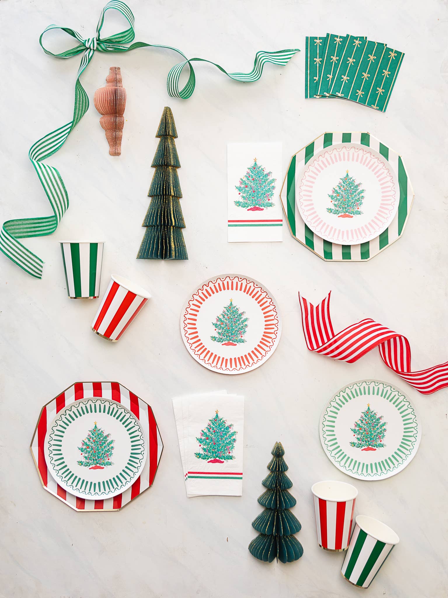 Holiday party flatlay featuring cherry red cabana stripe cups styled with Christmas plates and décor from Confetti My Party Toronto