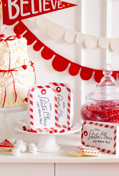 Holiday table styled with North Pole Treat Bags, Christmas banners and pennants, available at our Toronto party shop.