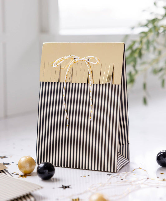 Black and white striped gift bag with gold accents on a light surface, perfect for grad parties. Sold in Toronto and fast shipping Canada wide.