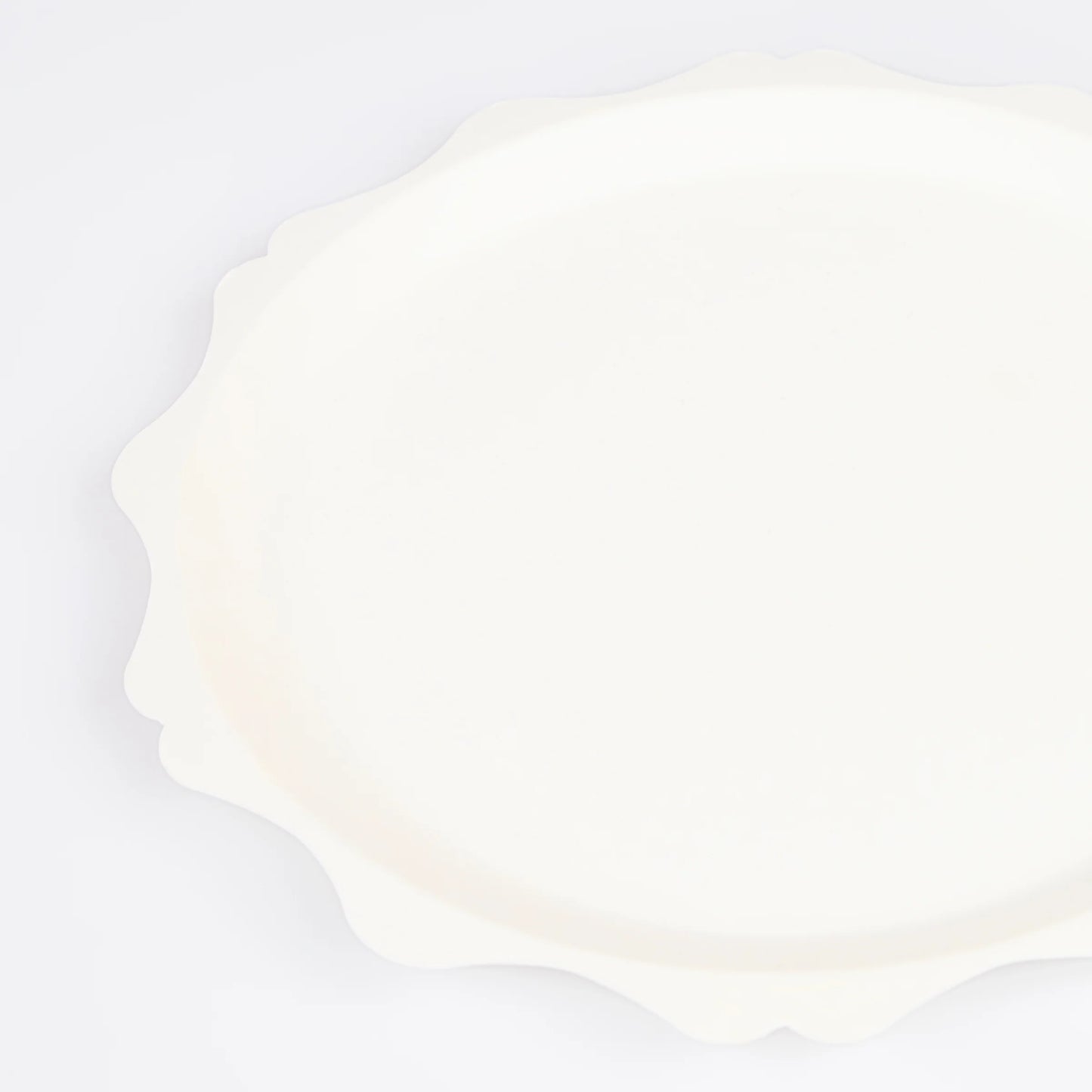 close up of decorative scalloped edge on cream dinner plate