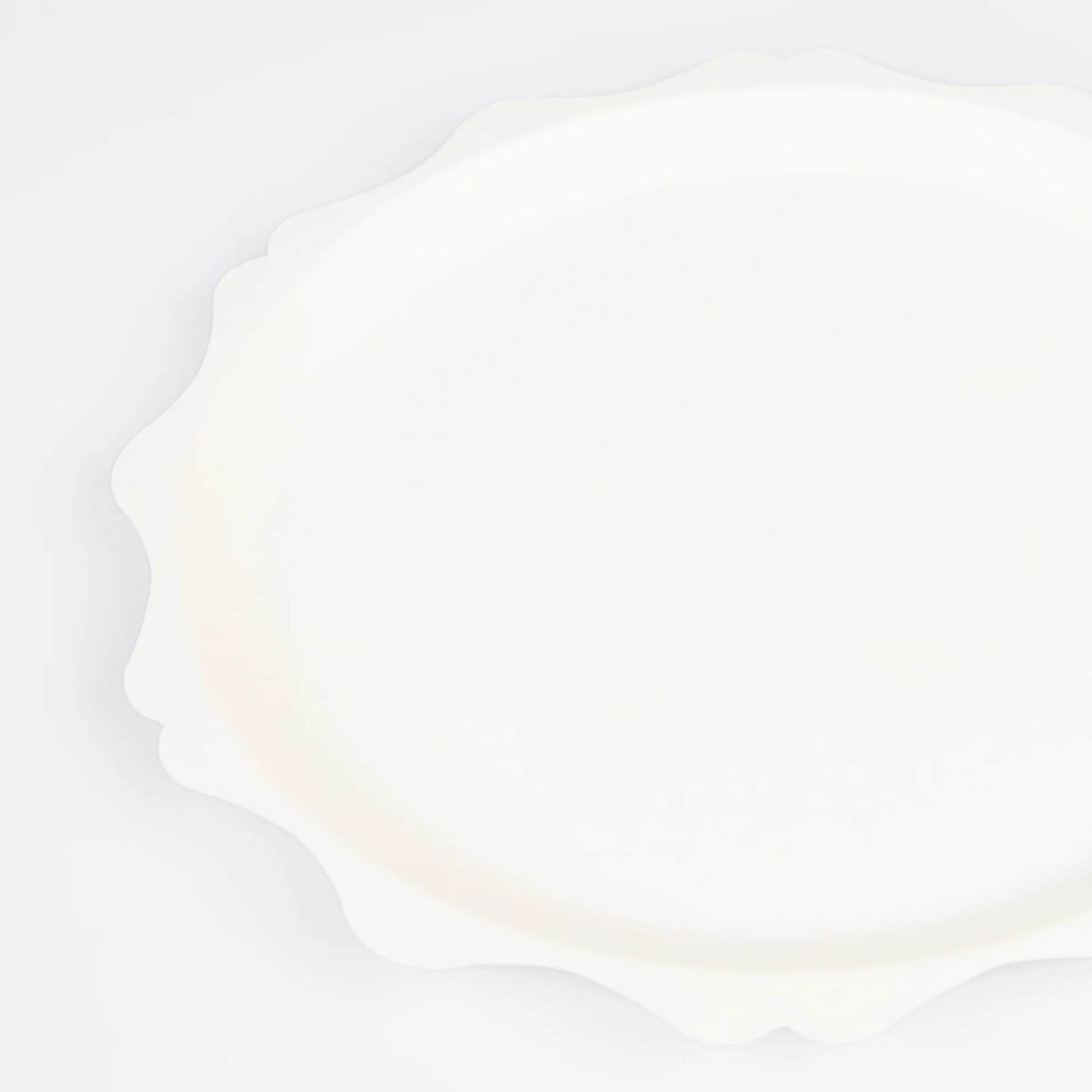 close up of decorative scalloped edge on cream dinner plate