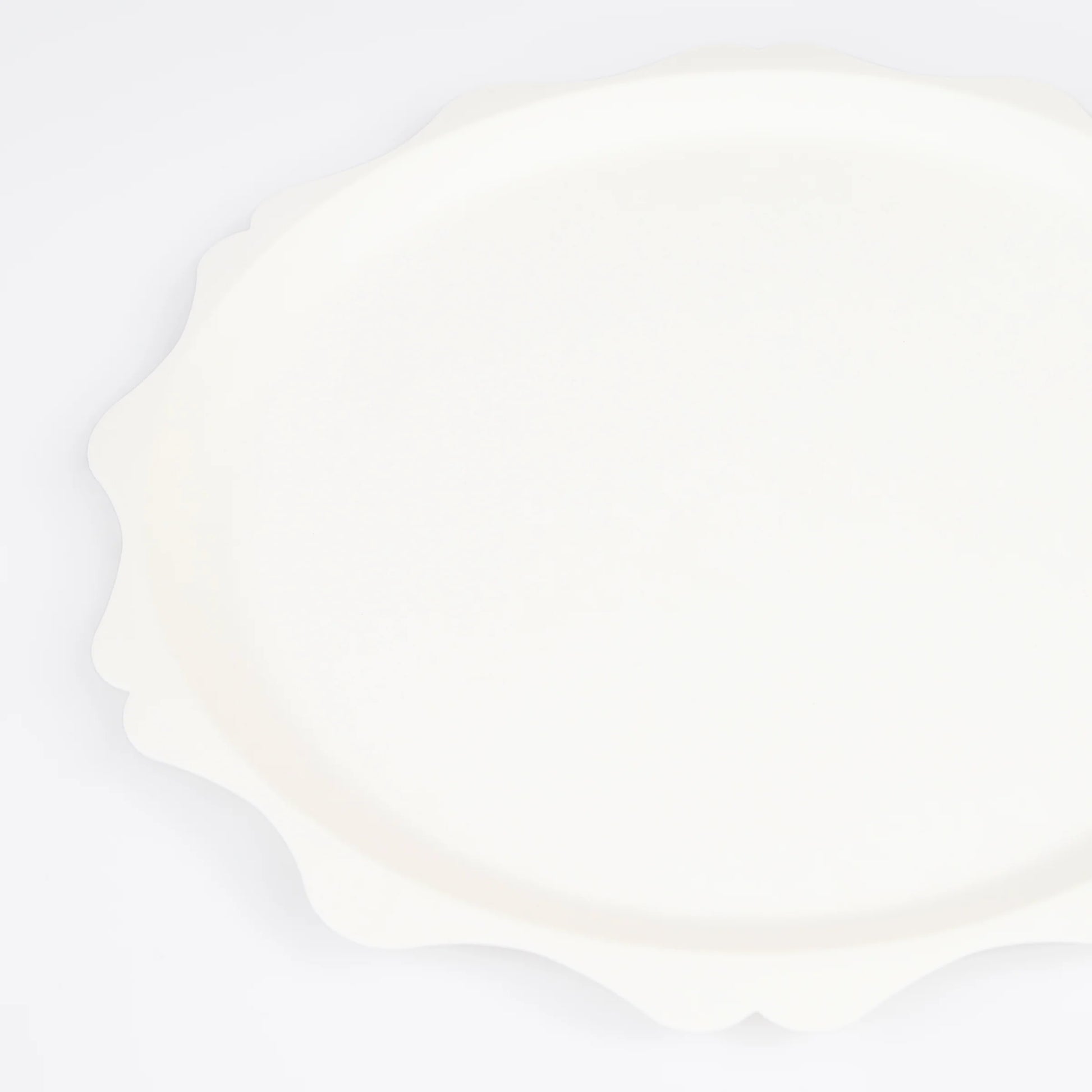 close up of side paper plate in cream colour with decorative scalloped edge