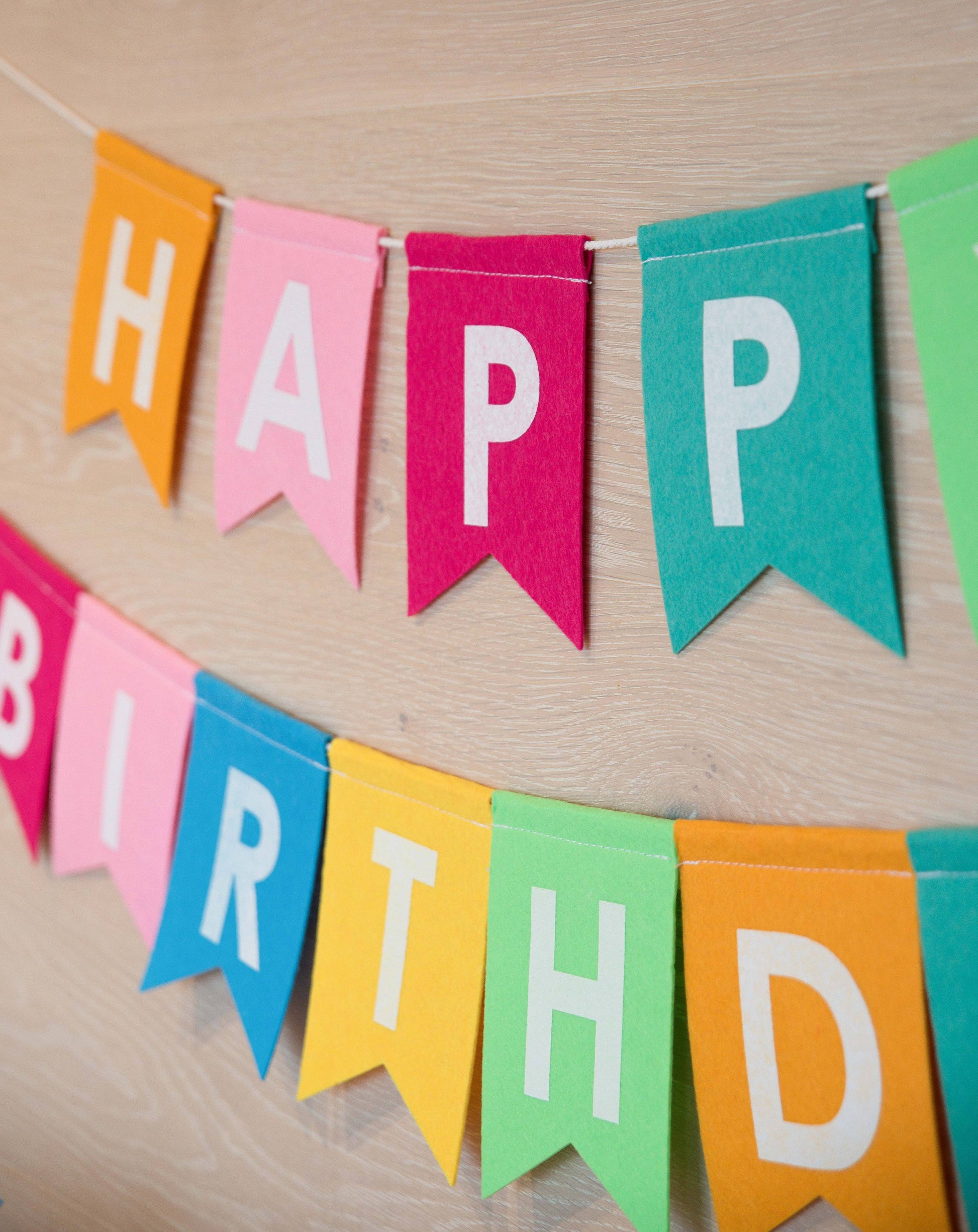 Colorful 'Happy Birthday' banner on a wooden surface
