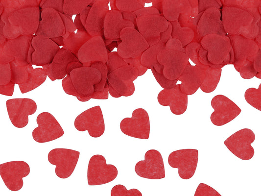 Red heart tissue-paper confetti scattered across a white surface, decorative party confetti available in Toronto with fast Canada-wide shipping.