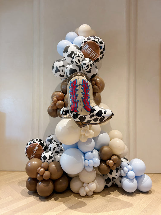 Cowboy themed balloon garland with western boot foil balloon and cow print details, styled for a Toronto western birthday party.