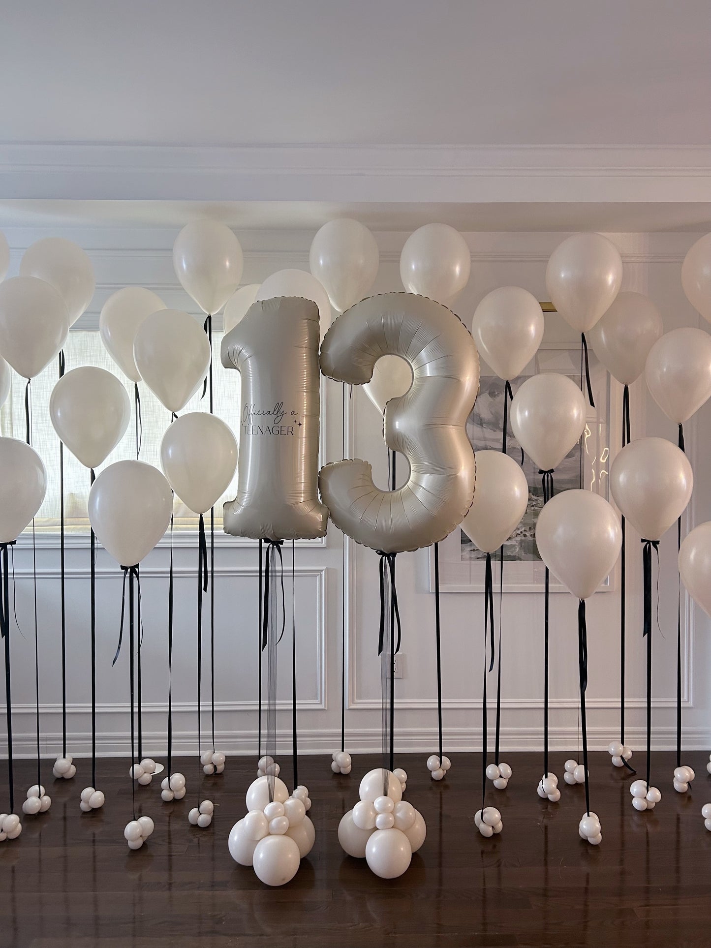 Cream birthday balloon package with customizable number balloons and black ribbon + bow accents, available in Toronto.