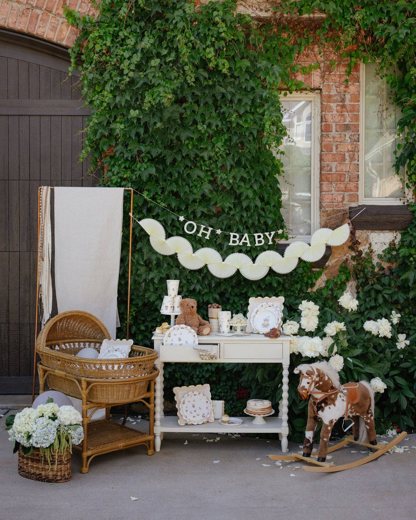 Cream tissue paper bunting banner shown in a baby shower setup, sold in Toronto at our party shop. Canada-wide delivery available.