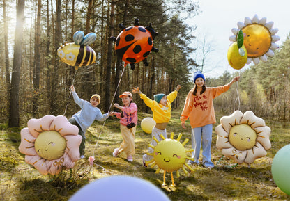 Children playing with balloons shaped like flowers and animals in a forest.