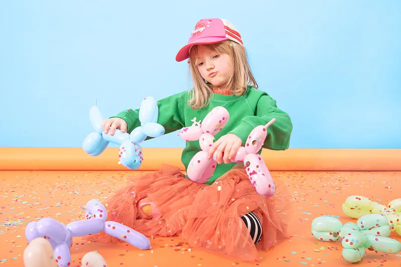 child playing with balloon dogs