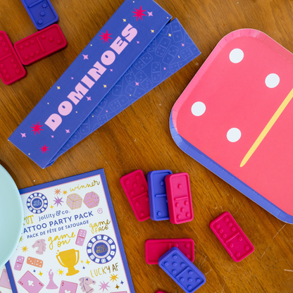 Party setup featuring Dominoes Paper Plates and colourful game night tableware with dice and domino pieces, available in Toronto and shipping across Canada.