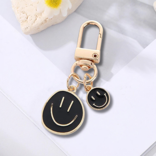 gold keychain with double happy face pendant in black