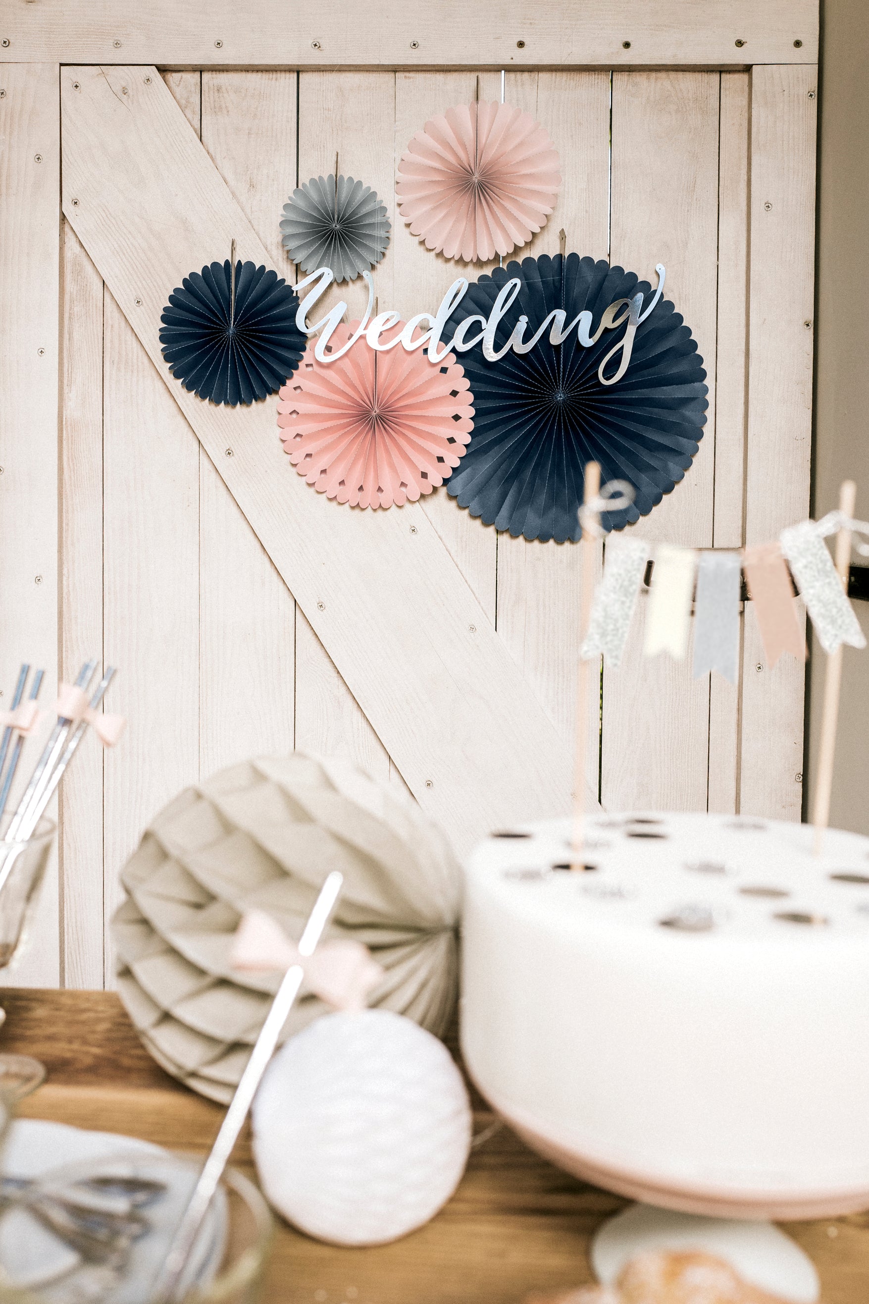 Wedding backdrop with peach pink and grey paper rosettes available at our Toronto party shop