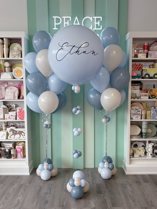 Custom blue sacrament balloon setup featuring a large personalized helium balloon and matching bouquets for a First Communion in Toronto.
