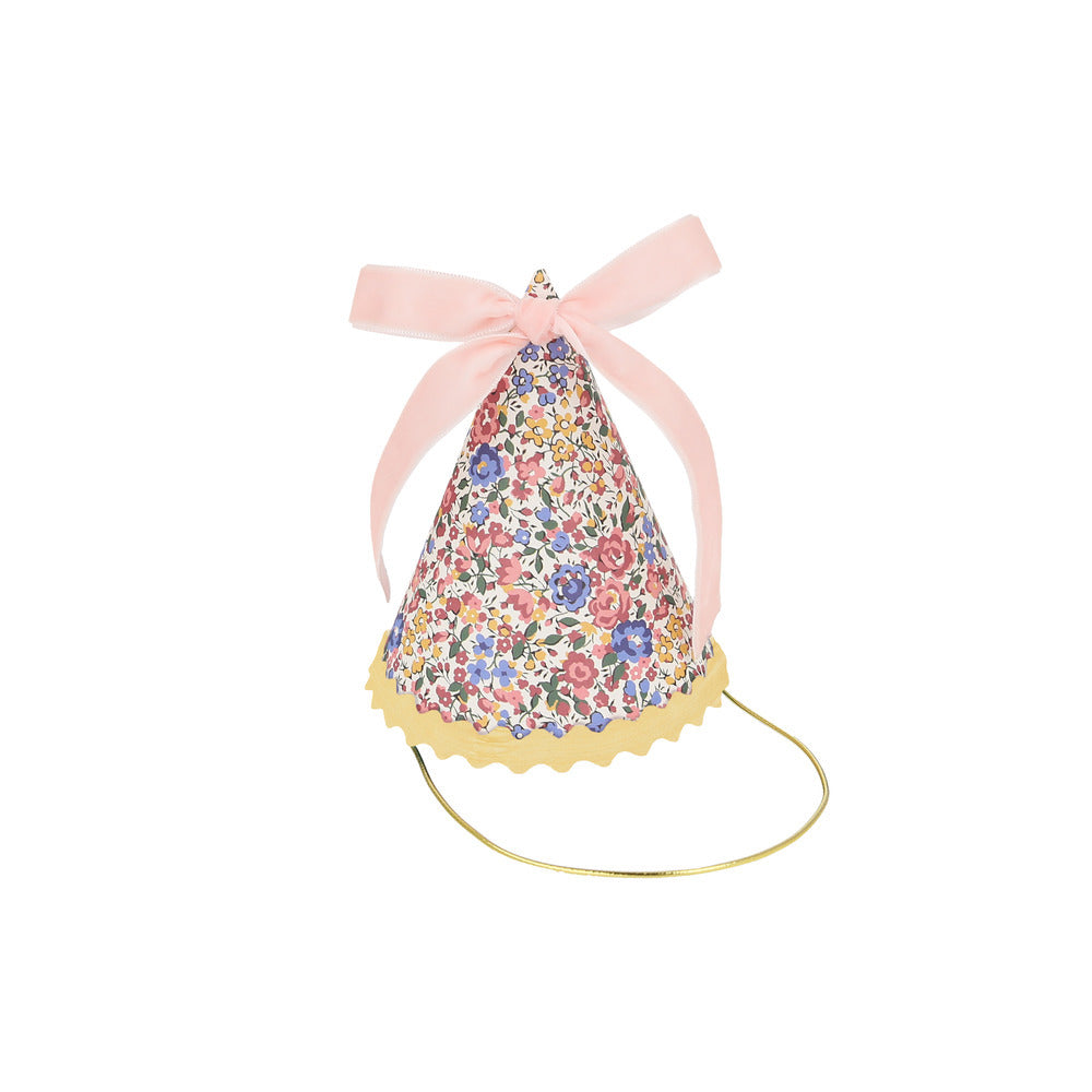 Close up of Liberty floral party hat with pink velvet bow and scalloped detail, available at our Toronto party shop