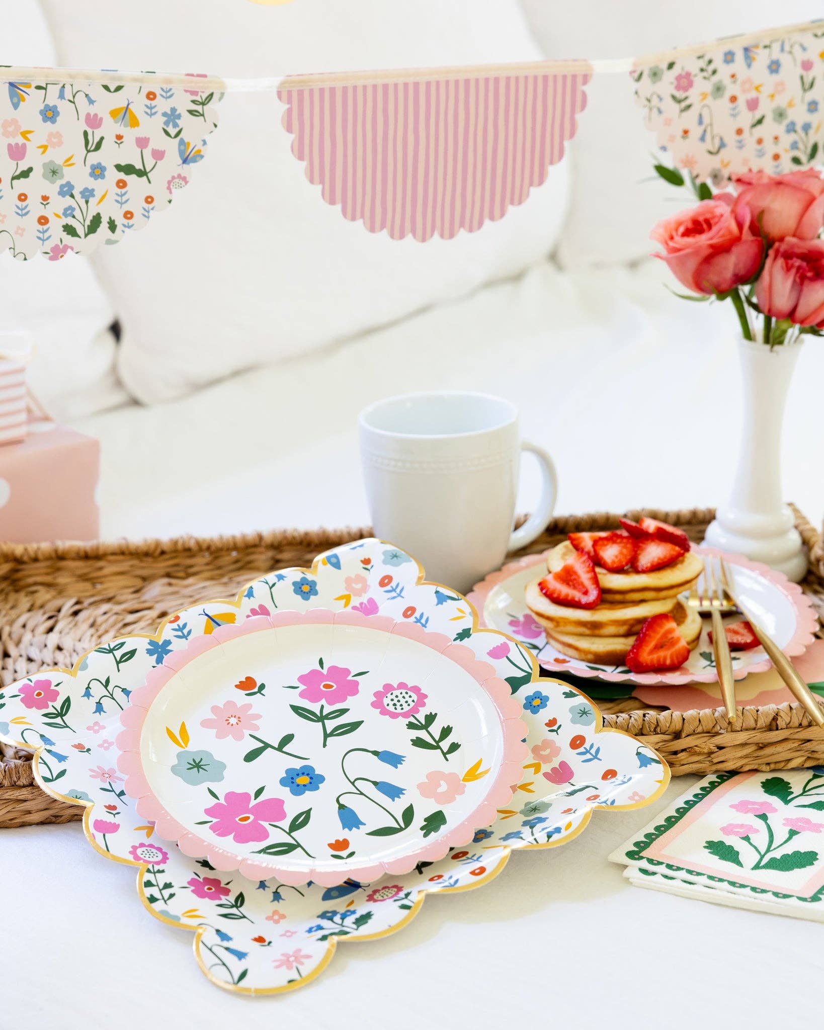Floral plates and a mug on a table with a decorative background