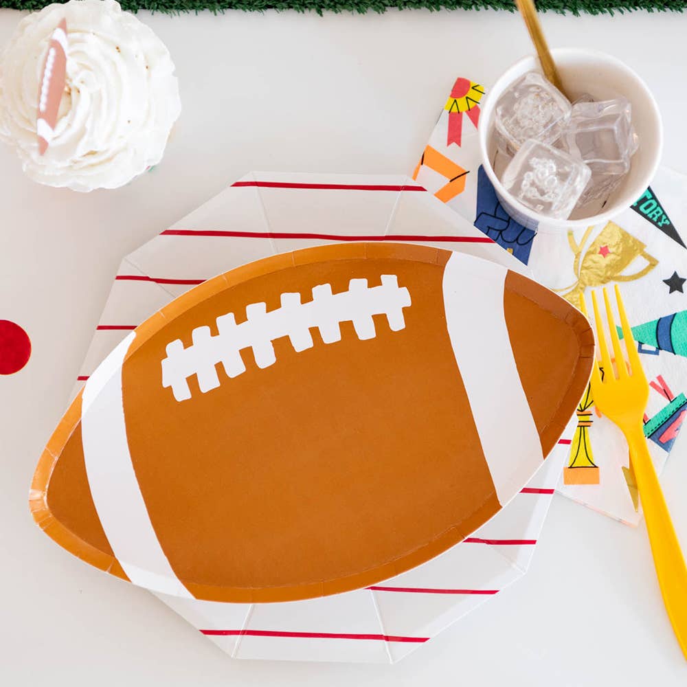 Football-shaped paper plate on a table with decorative elements