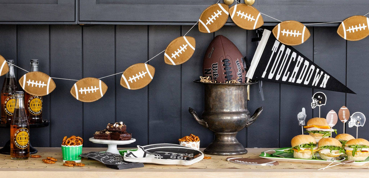 Puffy felt football banner styled above a football themed game day party table