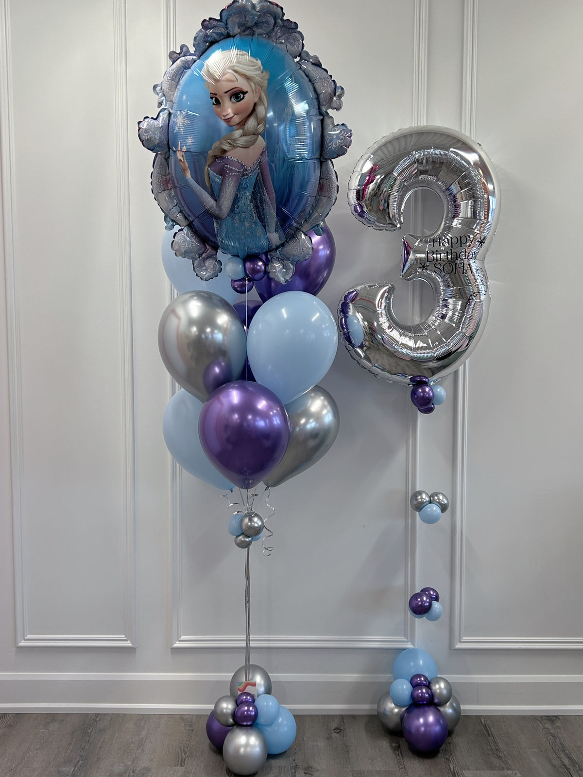 Frozen Elsa birthday balloon bundle with a large Elsa foil balloon, personalized silver number 3, icy blue, purple and silver helium balloons and decorative balloon bases in Toronto.