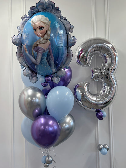 Close-up of Frozen Elsa birthday balloons featuring an Elsa supershape foil balloon, silver number 3 with personalized birthday message and coordinating blue, purple and silver latex balloons.