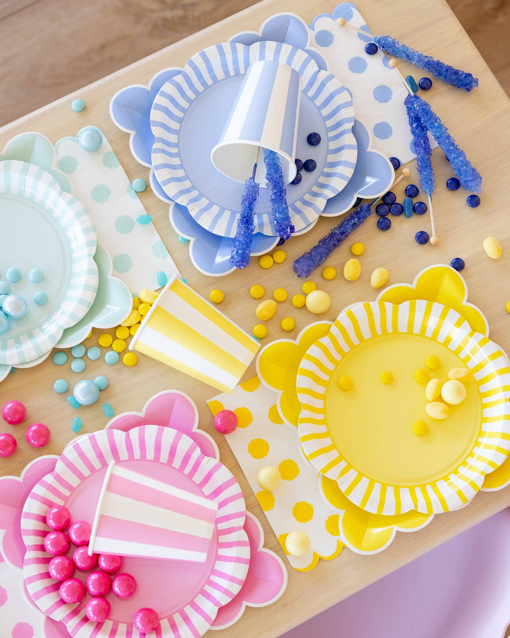 Fuchsia scalloped square paper plate styled with colourful pink, blue and yellow party tableware.