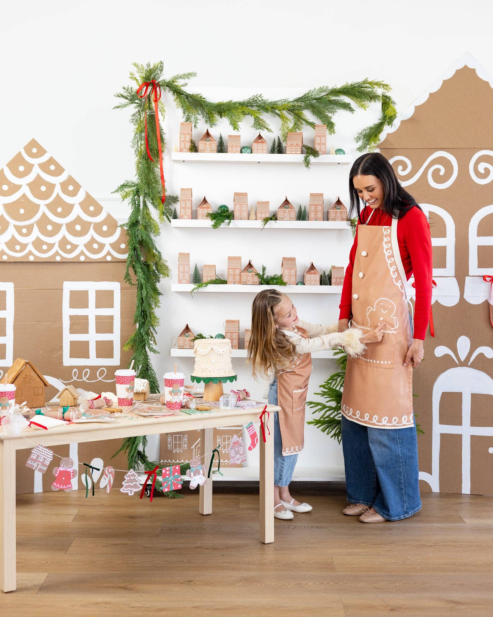 Mother and daughter wearing matching gingerbread aprons while baking holiday treats, available for pick up in Toronto and ships across Canada.