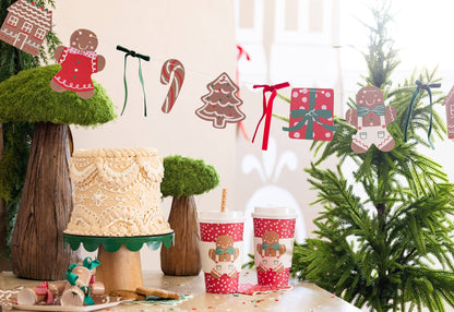 Christmas gingerbread garland with candy and present cutouts strung with ribbon, ideal for festive parties