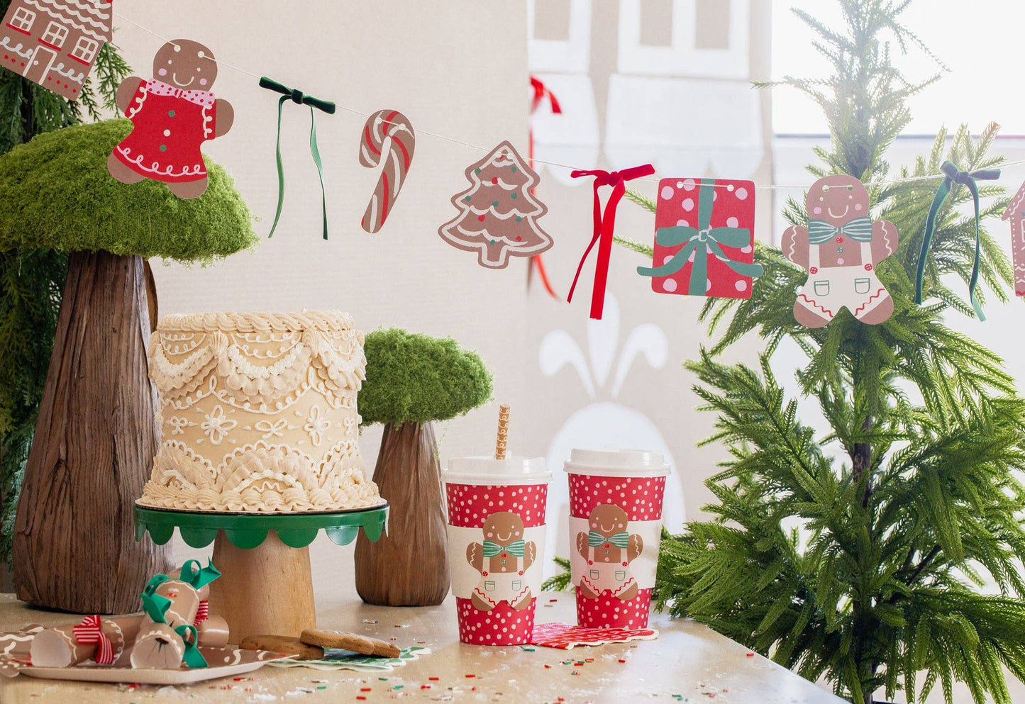 Christmas party table with gingerbread-themed to-go cups, festive cake, and holiday garland, perfect for celebrations in Toronto.