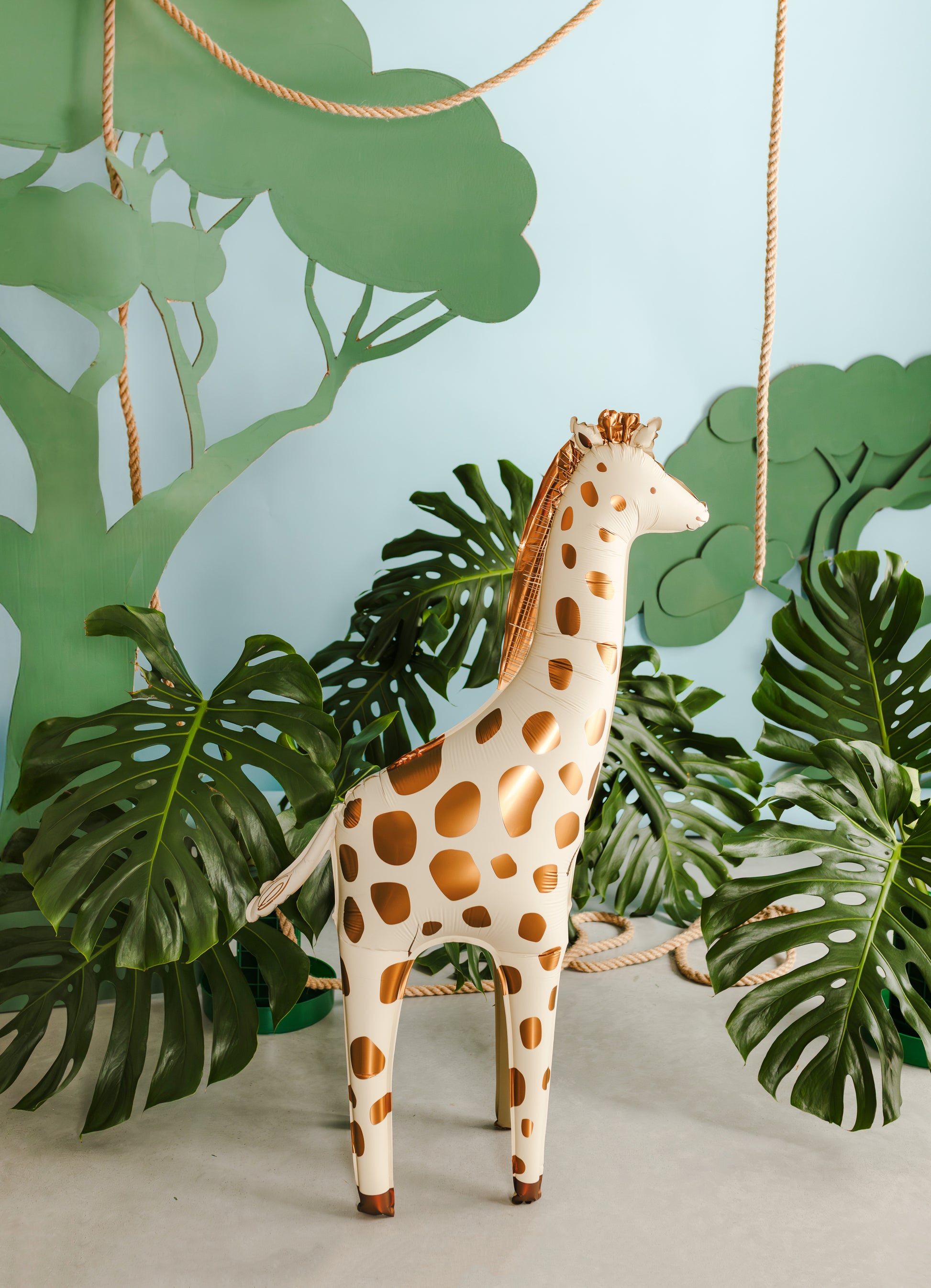 Giraffe foil balloon styled in a jungle-themed setup with tropical leaves, perfect for kids’ parties available at our Toronto party shop.