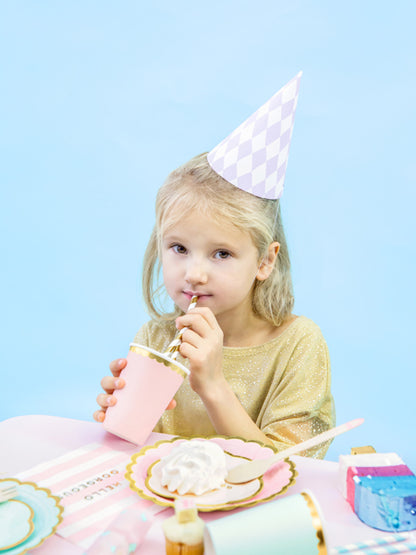 child drinking from gold and white striped straw at children's party