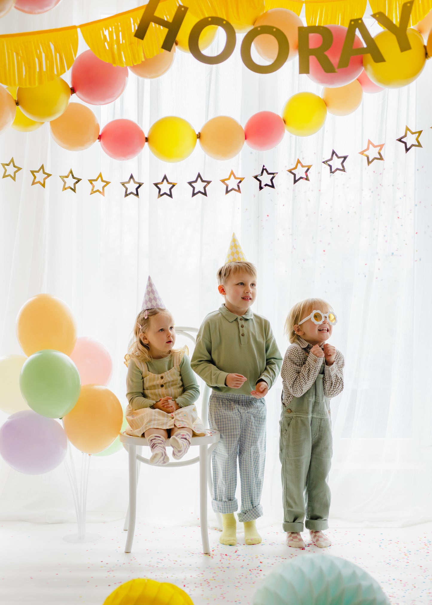 Metallic gold star garland hanging behind a pastel birthday party setup available at our Toronto party shop