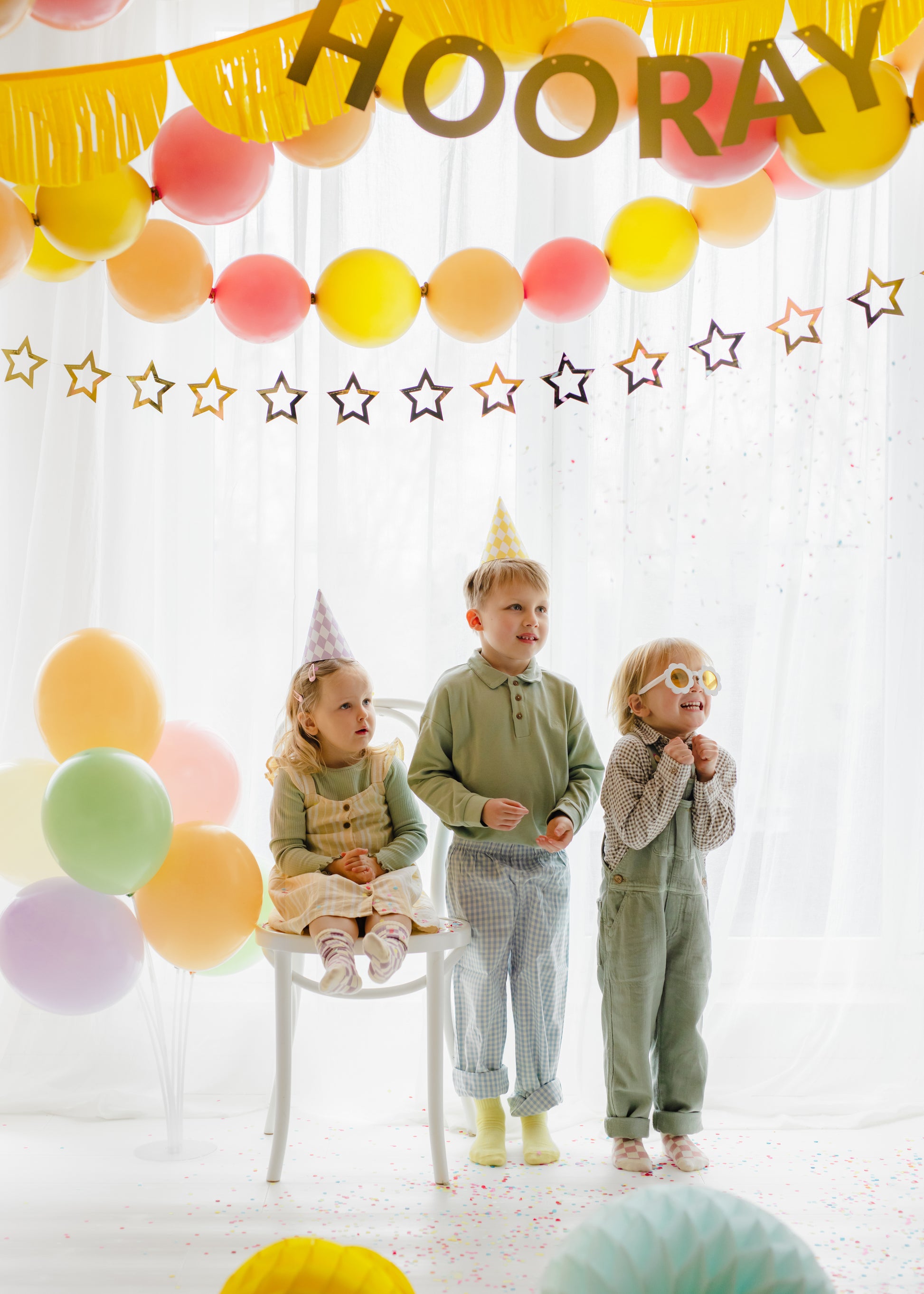 Metallic gold star garland hanging behind a pastel birthday party setup available at our Toronto party shop