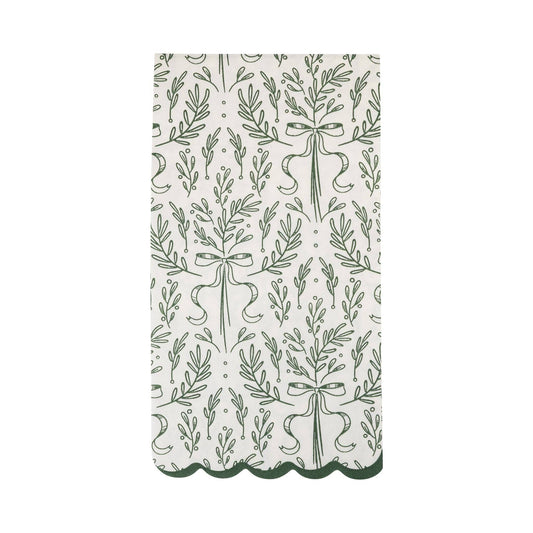 White scalloped paper dinner napkin with green bough and ribbon design, perfect for Toronto holiday tables.