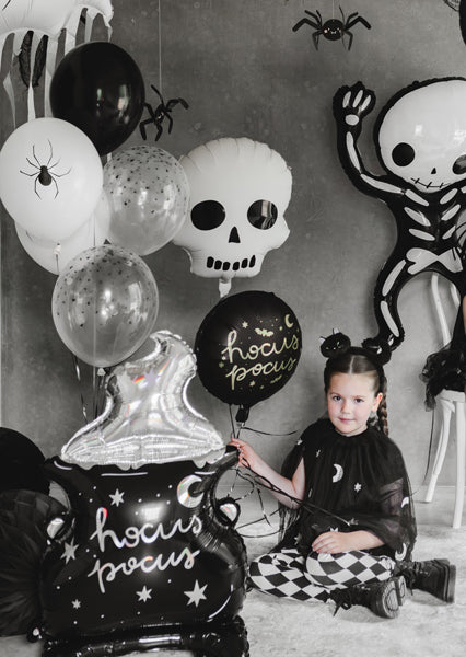 Child in Halloween-themed room with balloons and decorations