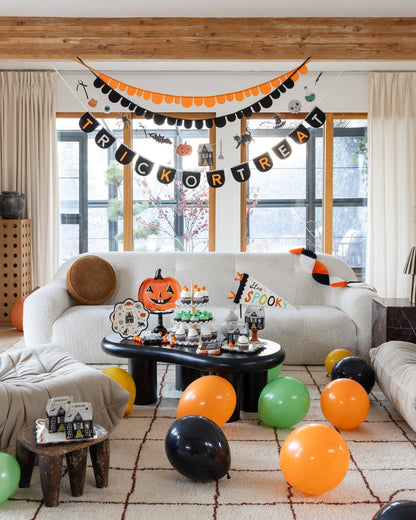 Halloween icons garland and trick or treat banner styled with orange, black and green Halloween party decorations.