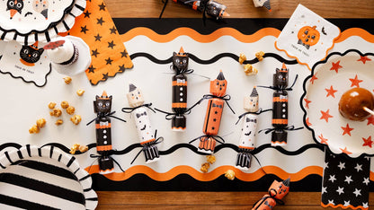 Halloween-themed table setting with decorative party crackers and halloween decor tablescape.