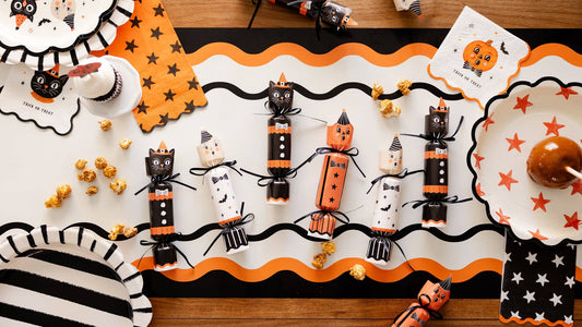 Halloween-themed table setting with decorative party crackers and halloween decor tablescape.