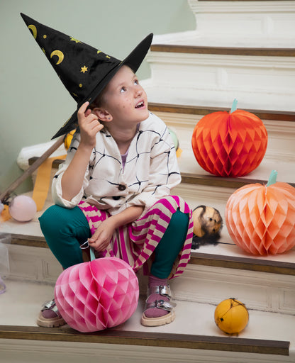 Girl with tissue paper pumpkins in pink and orange, fun Halloween décor, shipping across Canada.