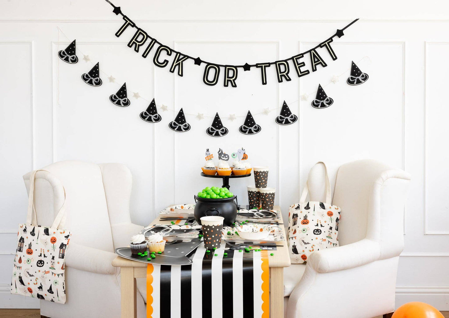 Halloween-themed table setting with 'Trick or Treat' banner and decorative items.