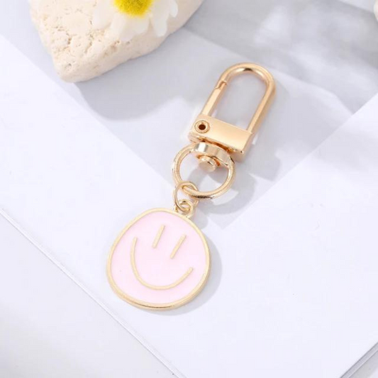mini happy face keychain in a light pink colour 