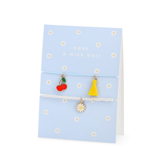 Blue ‘Have a Nice Day’ card with daisy print, cherry charm, yellow tassel charm, and pearl bracelet, available in Toronto and shipping across Canada.