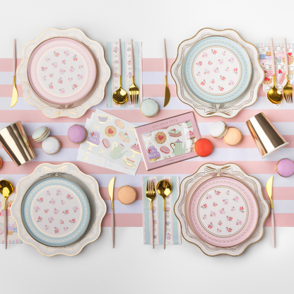 High tea party table setting with pastel floral plates, patisserie napkins, gold cutlery and macarons