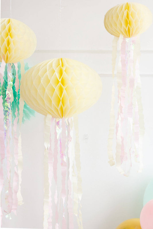 Decorative yellow honeycomb balls with tassels on a light background